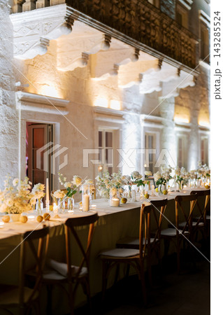 Tender wedding reception featuring glowing candles and vibrant floral arrangements for celebration 143285524