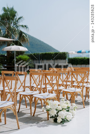 Coastal wedding setup. Charming seaside ceremony featuring floral aisles and mountain views 143285628