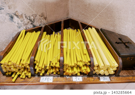 Handcrafted Beeswax Candles On Wooden Shelf. Closeup Of Organic Beeswax Candles With Tags Handcrafted Beeswax Candles On Wooden Shelf. Closeup Of Organic Beeswax Candles With Tags 143285664
