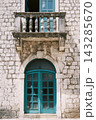 Timeworn Masonry Facade Featuring Teal Entrance And Ornate Carved Balustrade Balcony 143285670