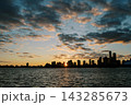Tranquil City Silhouette During Dusk With Glowing Clouds And Peaceful River Reflection 143285673