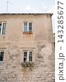 Calm Mediterranean Setting Featuring Sunlit Cracked Stucco Walls And Vibrant Window Boxes 143285677