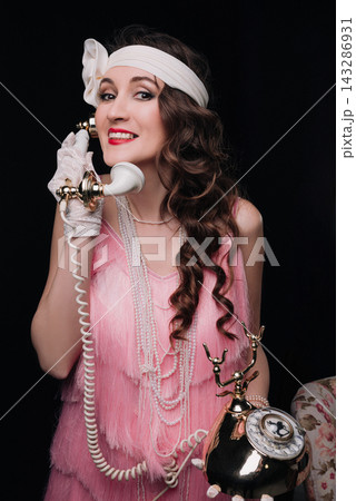 Elegant young woman and girl talking on a vintage rotary telephone Elegant young woman and girl talking on a vintage rotary telephone 143286931