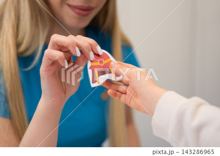 Close-up of a woman's and child's hands with a paper firefighter helmet 143286965