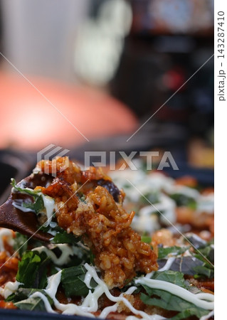 Close-Up of Savory Rice Dish with Greens and Sauce 143287410