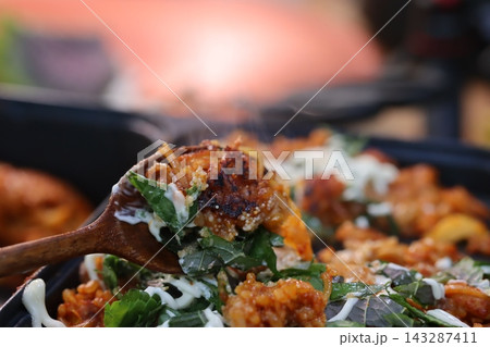 Sizzling Skillet Dish with Fresh Greens and Creamy Sauce 143287411