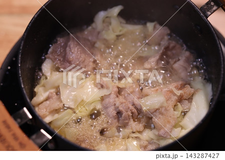 Sizzling Meat and Cabbage in Cooking Pan 143287427