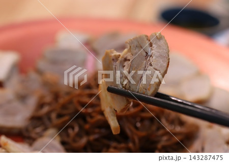 Chopstick Holding Sliced Meat Over Noodle Dish Chopstick Holding Sliced Meat Over Noodle Dish 143287475