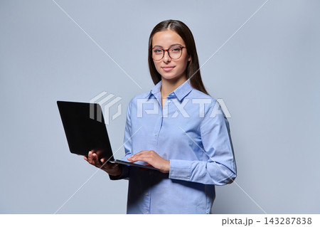 Young woman in glasses using laptop computer studio shot Young woman in glasses using laptop computer studio shot 143287838