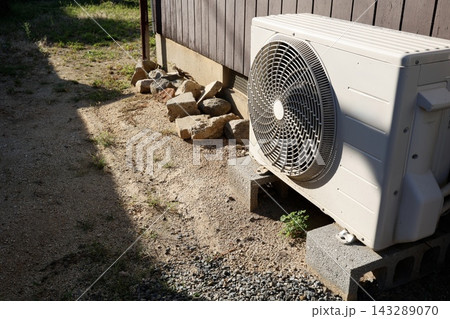 日光に照らされたエアコンの室外機。木製外壁脇の屋外設備 143289070