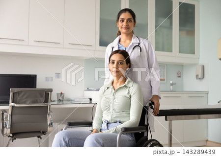 Portrait of young woman in wheelchair and physiotherapist Portrait of young woman in wheelchair and physiotherapist 143289439