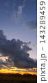暗い雲の向こうに広がる黄金色の夕焼け空 143289459