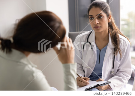 Depressed woman during consultation with female psychologist Depressed woman during consultation with female psychologist 143289466