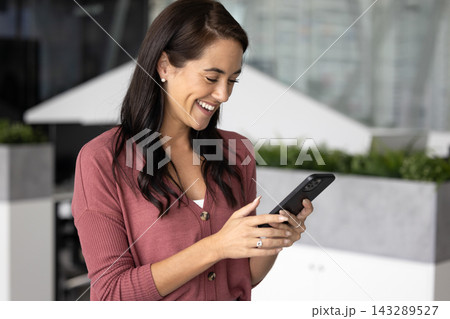 Smiling woman using smartphone in modern workplace Smiling woman using smartphone in modern workplace 143289527