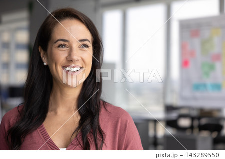 Head shot portrait of confident businesswoman standing in contemporary workspace 143289550