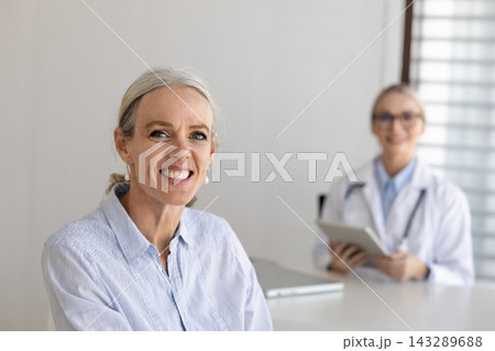 Portrait of smiling middle-age female patient during medical consultation 143289688