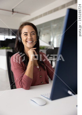Portrait of smiling woman, callcenter employee posing seated at desk 143289724