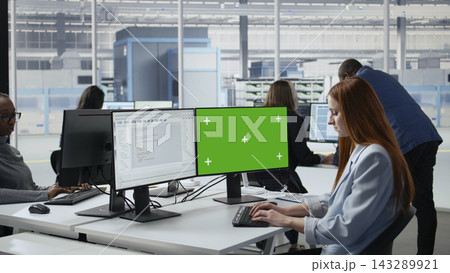 Green screen PC used by woman coding in microchip factory office. Female programmer using chroma key mockup computer to do software optimization in semiconductor manufacturing plant RD lab, camera A Green screen PC used by woman coding in microchip factory office. Female programmer using chroma key mockup computer to do software optimization in semiconductor manufacturing plant RD lab, camera A 143289921