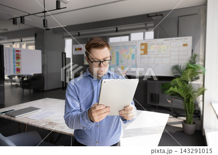 Young man with Down syndrome using tablet in office 143291015