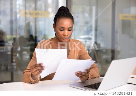 Serious African office employee do paperwork at workplace Serious African office employee do paperwork at workplace 143291421
