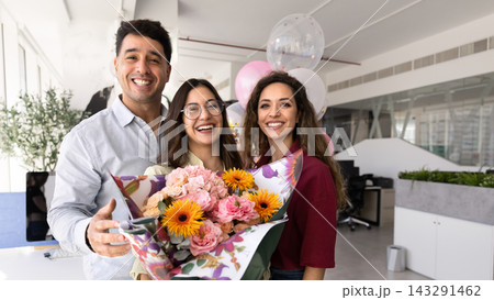 Happy colleagues posing for corporate portrait with flowers and balloons 143291462