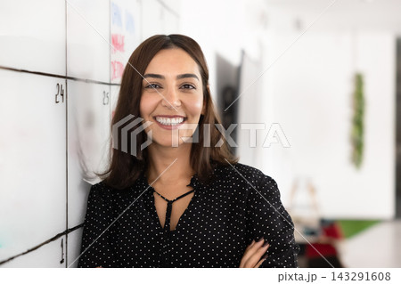 Confident woman smiling in modern creative office, head shot Confident woman smiling in modern creative office, head shot 143291608