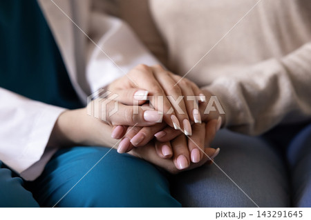 Closeup of caregiver doctor holding hand of senior woman patient Closeup of caregiver doctor holding hand of senior woman patient 143291645