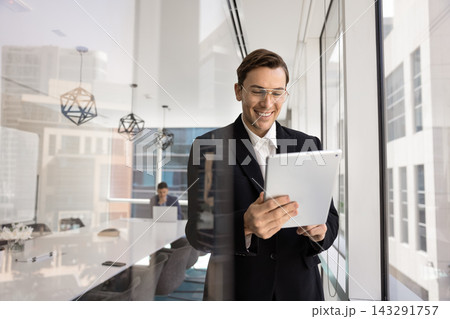 Smiling corporate employee interacting with tablet device at modern boardroom Smiling corporate employee interacting with tablet device at modern boardroom 143291757
