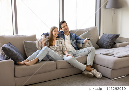 Young 30s relaxed couple enjoying movie time at home Young 30s relaxed couple enjoying movie time at home 143292010
