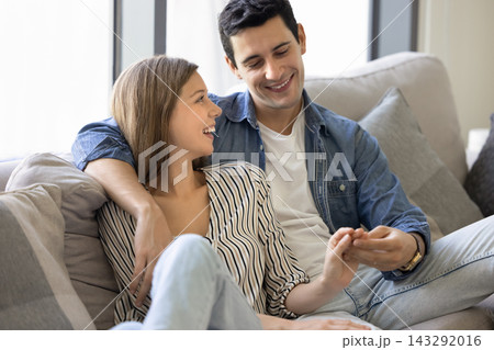 Young couple enjoying casual talk seated on sofa 143292016