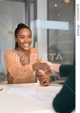 Smiling African woman shaking hands after successful job interview 143292078