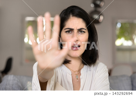 Anxious scared young Hispanic woman showing hand stop at camera Anxious scared young Hispanic woman showing hand stop at camera 143292694