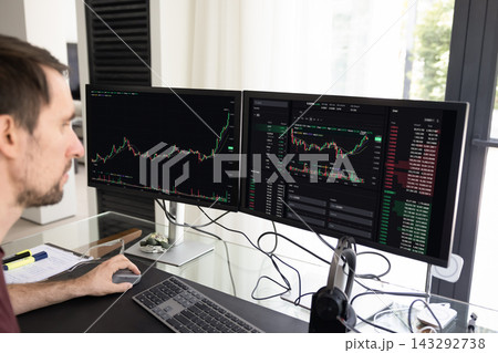 Man analyzing stock market charts on computer Man analyzing stock market charts on computer 143292738