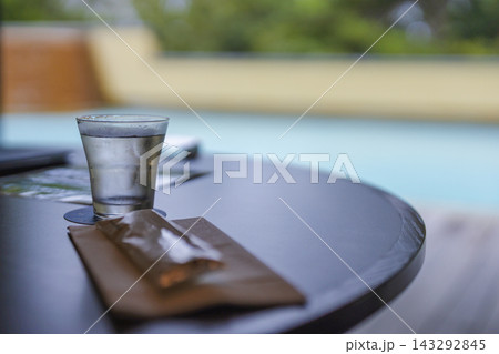 プールを背景にテーブルへ置かれた水のグラス お冷 プールを背景にテーブルへ置かれた水のグラス お冷 143292845
