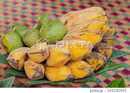 Tropical yellow bananas and green hog plums in a bowl 143292855