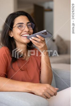 Happy woman using voice assistant on smartphone Happy woman using voice assistant on smartphone 143292929