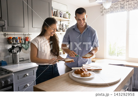 Couple preparing together morning sandwiches for breakfast Couple preparing together morning sandwiches for breakfast 143292958