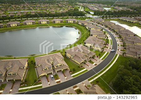 Aerial view of tightly located family houses with retention ponds to prevent flooding in Florida closed suburban area. Real estate development in american suburbs 143292965