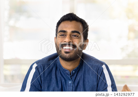Head shot portrait Indian man laughing, looking into distance 143292977