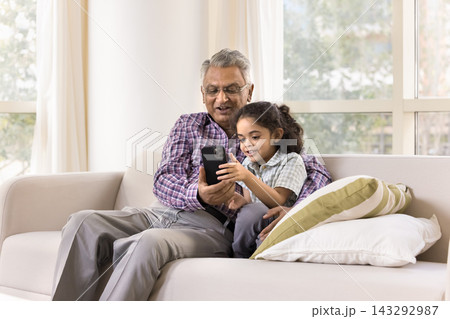 Older man spend time on internet with little great-grandson 143292987