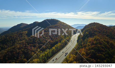 Aerial view of I-40 freeway in North Carolina leading to Asheville through Appalachian mountains in golden fall with fast moving trucks and cars. Interstate transportation concept Aerial view of I-40 freeway in North Carolina leading to Asheville through Appalachian mountains in golden fall with fast moving trucks and cars. Interstate transportation concept 143293047
