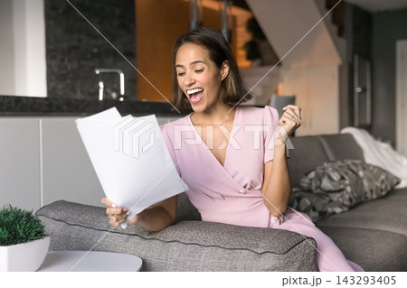 Excited gen z woman hold paper document scream yes 143293405