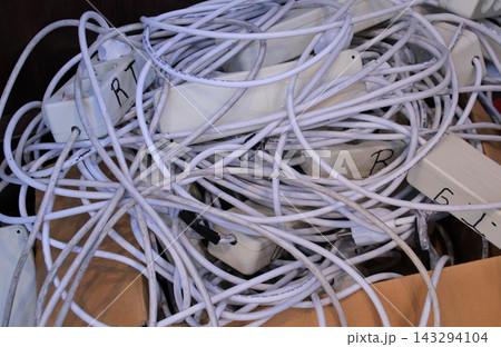 Tangled pile of white extension cables 143294104