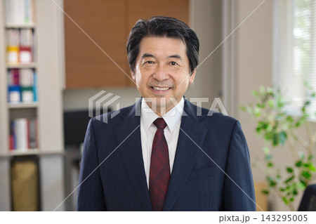 オフィスの窓際で微笑む60代男性 オフィスの窓際で微笑む60代男性 143295005
