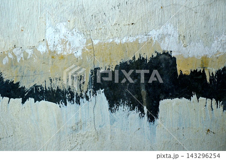 An abstract, distressed concrete wall with overlapping layers of white, yellow, and black paint. Textured background An abstract, distressed concrete wall with overlapping layers of white, yellow, and black paint. Textured background 143296254