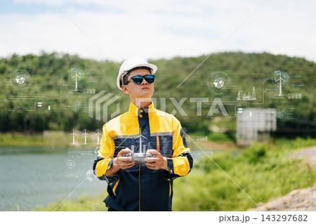 Asian engineer in hardhat landing a drone on his hand near wind turbines for renewable energy site inspection and survey. 143297682