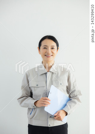 悩む作業服を着たミドル女性 悩む作業服を着たミドル女性 143299410