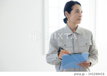 悩む作業服を着たミドル女性 悩む作業服を着たミドル女性 143299419