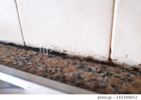 Black Mold on Silicone Sealant Between Tile and Countertop 143300652