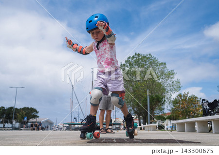 Cute Blonde Toddler in Safety Equipment Giving Thumbs Up Gesture Outdoors 143300675